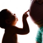 Un enfant qui touche le ventre de femme enceinte